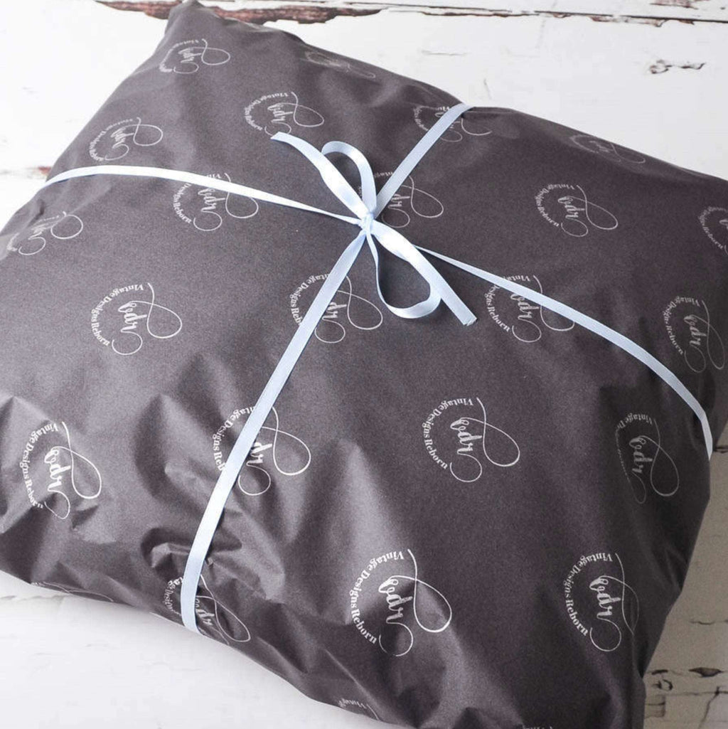 Gift-wrapped personalised cushion with ribbon and branded tissue paper, ready to give