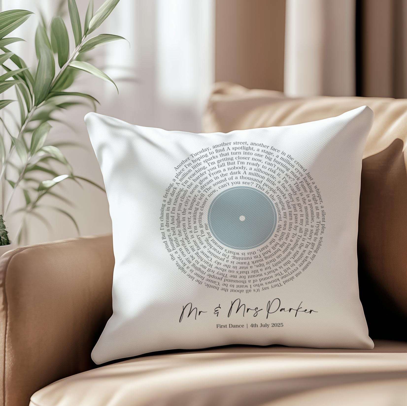 Custom cushion featuring first dance song lyrics in a spiral vinyl record design, personalised with names and date